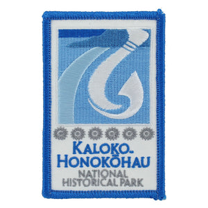 Rectangular blue and white patch shows fishhook and fishpond logo of Kaloko-Honokōhau National Historical Park on Hawaiʻi Island, as well as park name in blue on a white field.