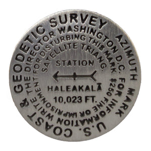 Circular metal geodesic survey marker shows height of Haleakalā national park along with other geographic data.