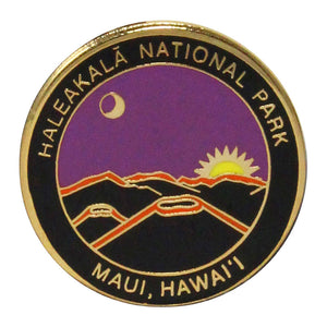 Round pin shows stylized depiction of the sun rising over the summit of Haleakalā volcano. Name of the park runs around the rim along with the location: Maui, Hawaiʻi. Pin is metal, purple, black and gold.